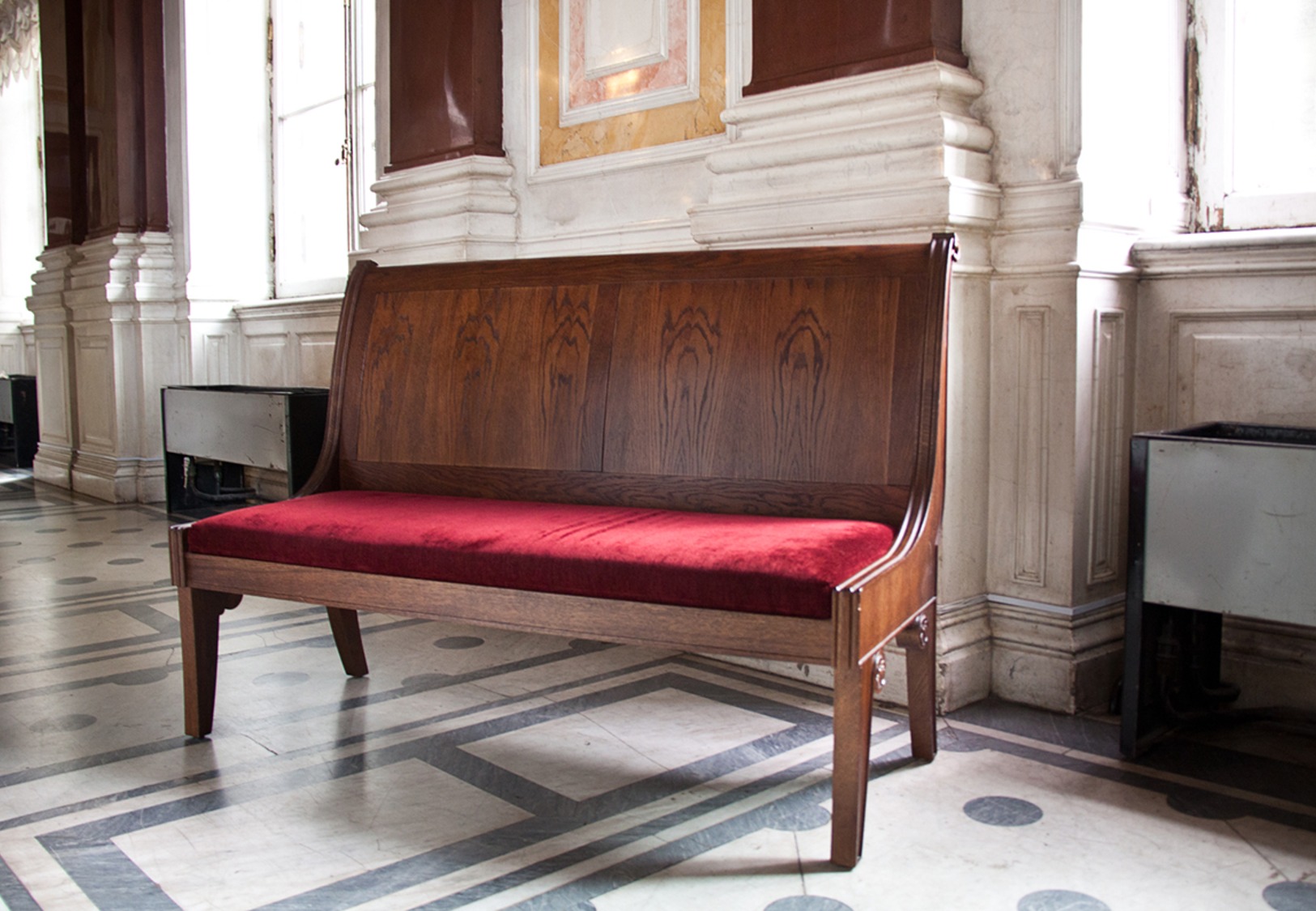 Banquette en bois et velours rouge dans une galerie de musée